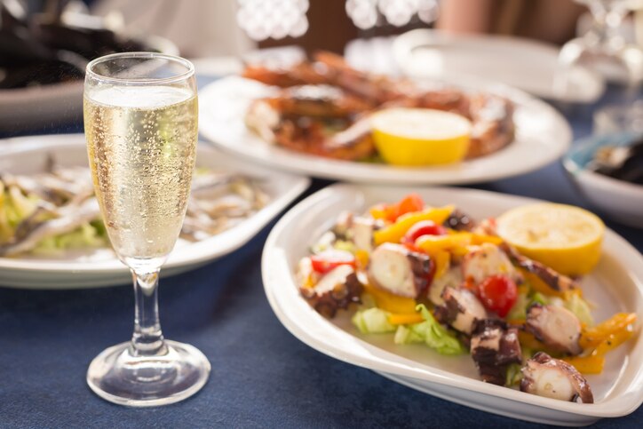 Italian cuisine. Glass of prosecco and variety of seafood. Shallow DOF, horizontal
