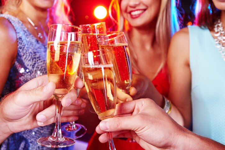 Group of friends clinking with flutes of champagne at party