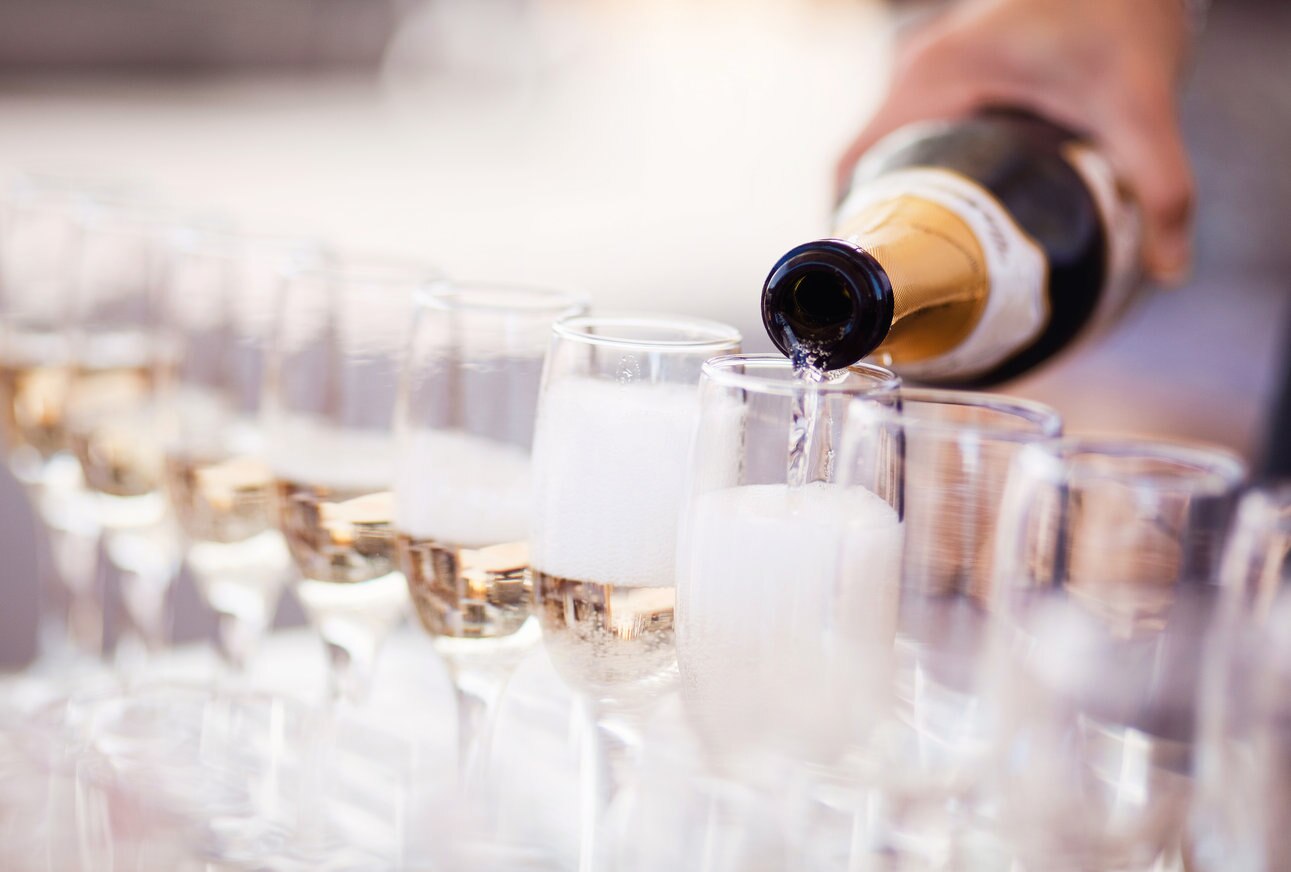 Waiter serving a glass of sparkling white wine