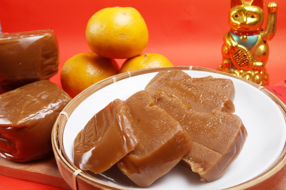 Chinese New Year sweets platter featuring nian gao (sticky rice cake) on a bamboo steamer