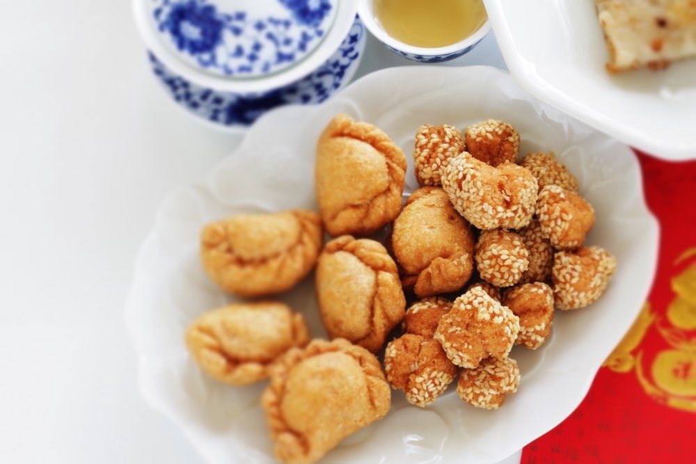 Lunar New Year snack, deep-fried sesame balls and baked curry puffs, with a blurred background